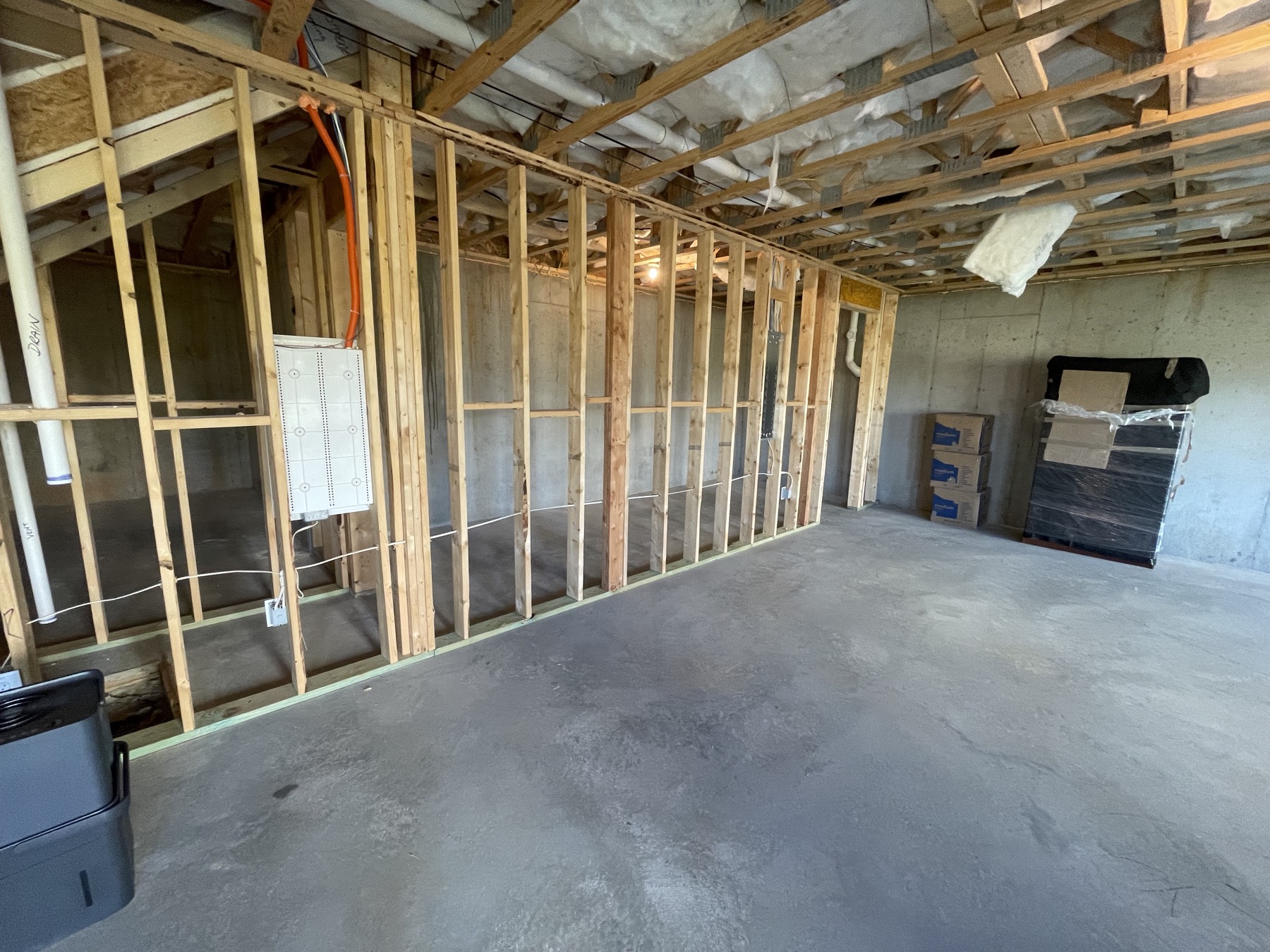 Unfinished basement bay window wall with exposed framing