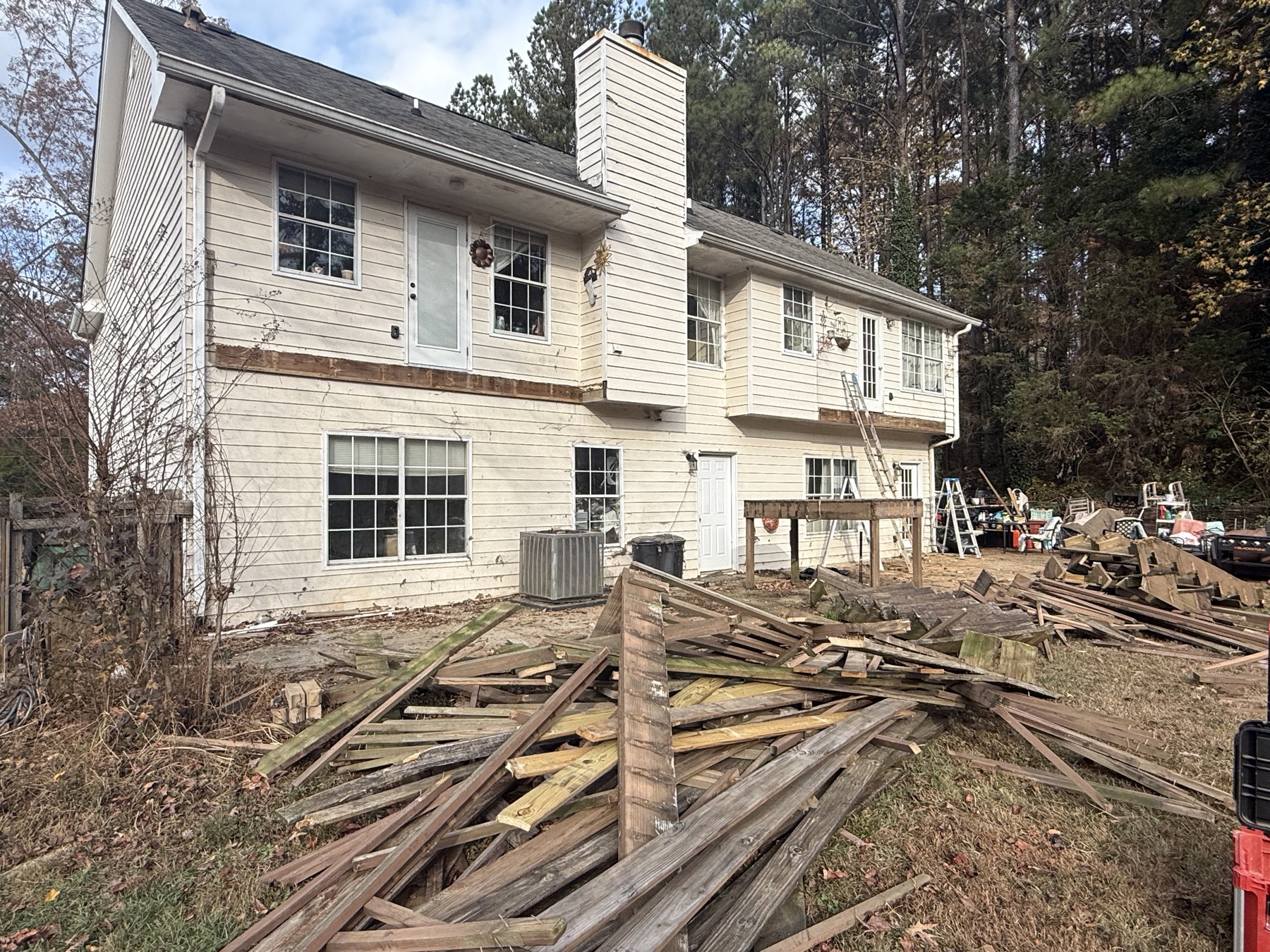 Deck fully removed, lumber debris pile in yard