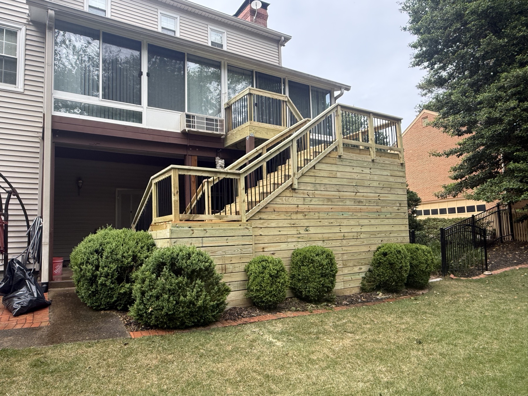 Finished stained deck with black railing after rebuild