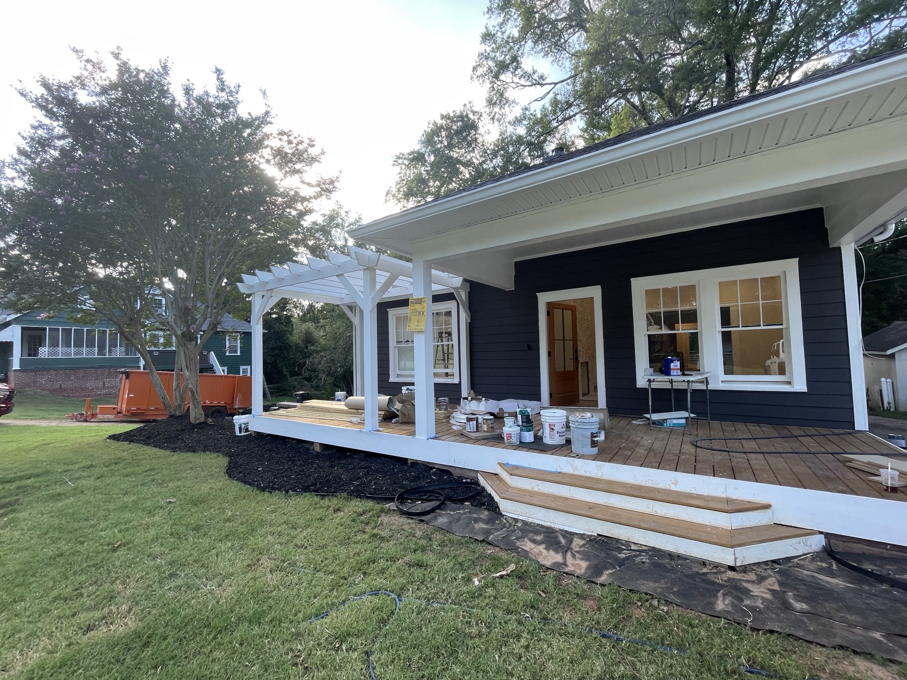 Finished navy exterior with white pergola and covered porch