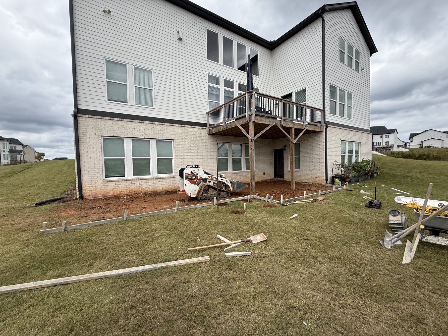 Backyard before concrete patio poured, existing deck above