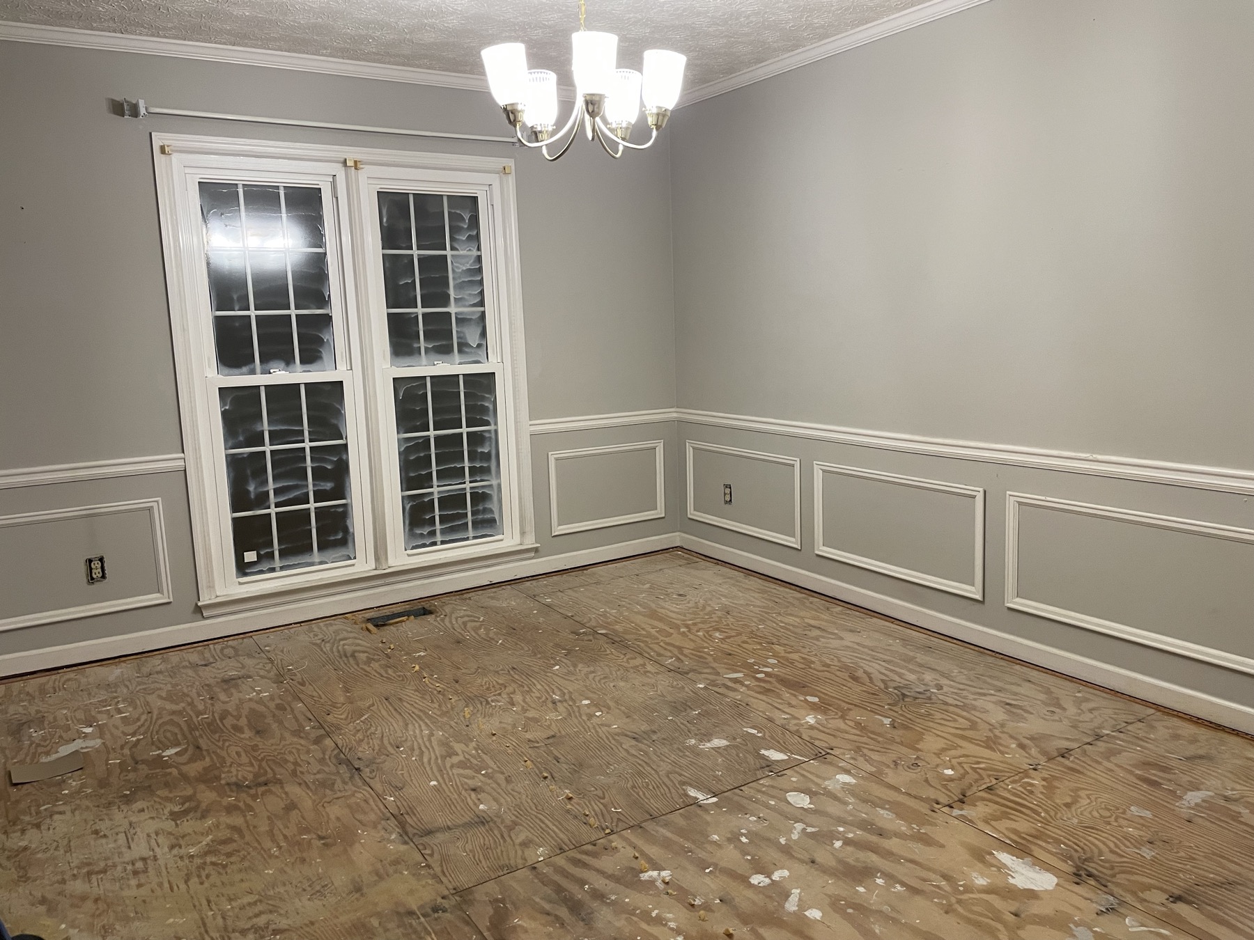 Room with bare subfloor before renovation